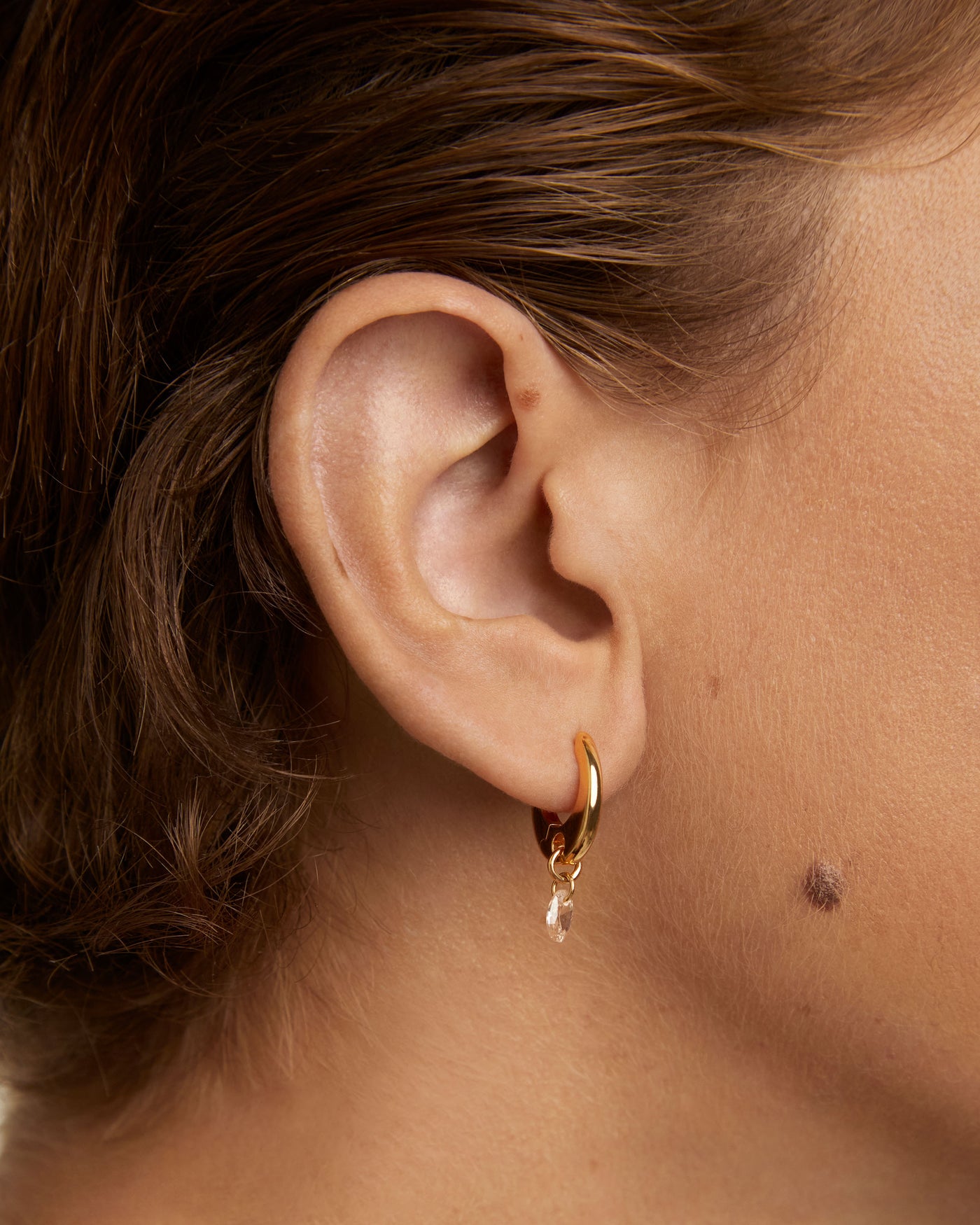 Gold-plated hoop earrings with a peach zirconia drop pendant