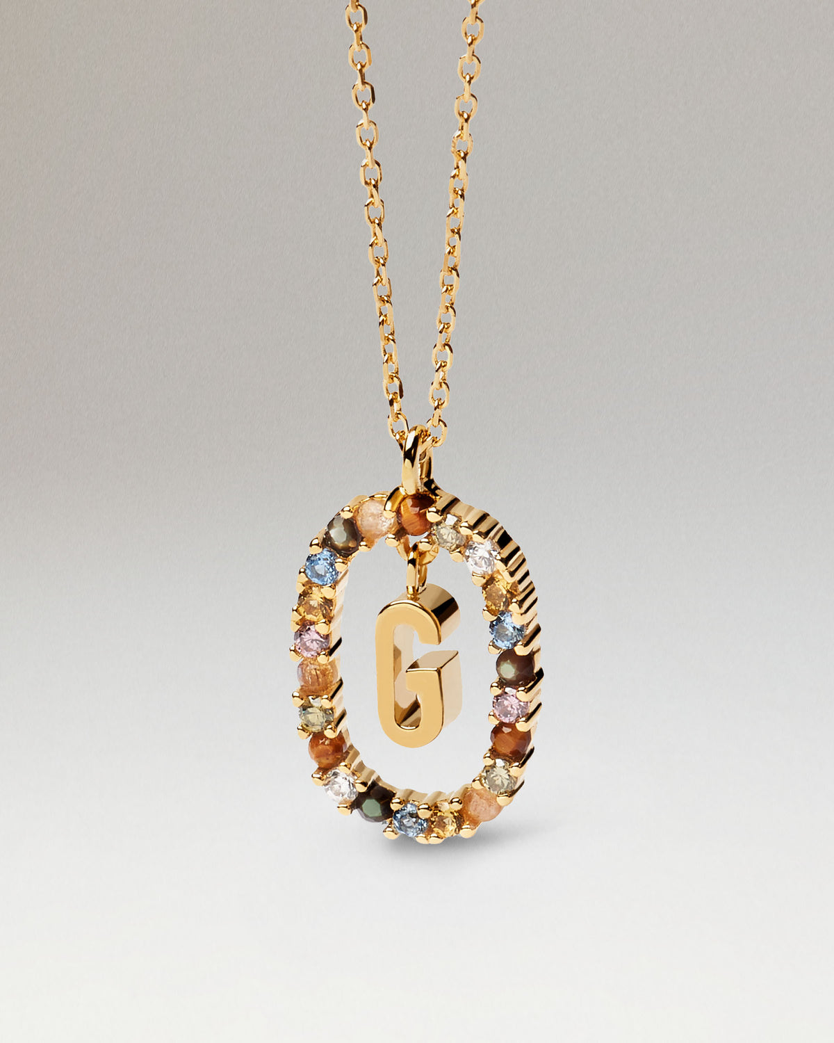 Collana con iniziale G placcato oro, circondata da gemme colorate