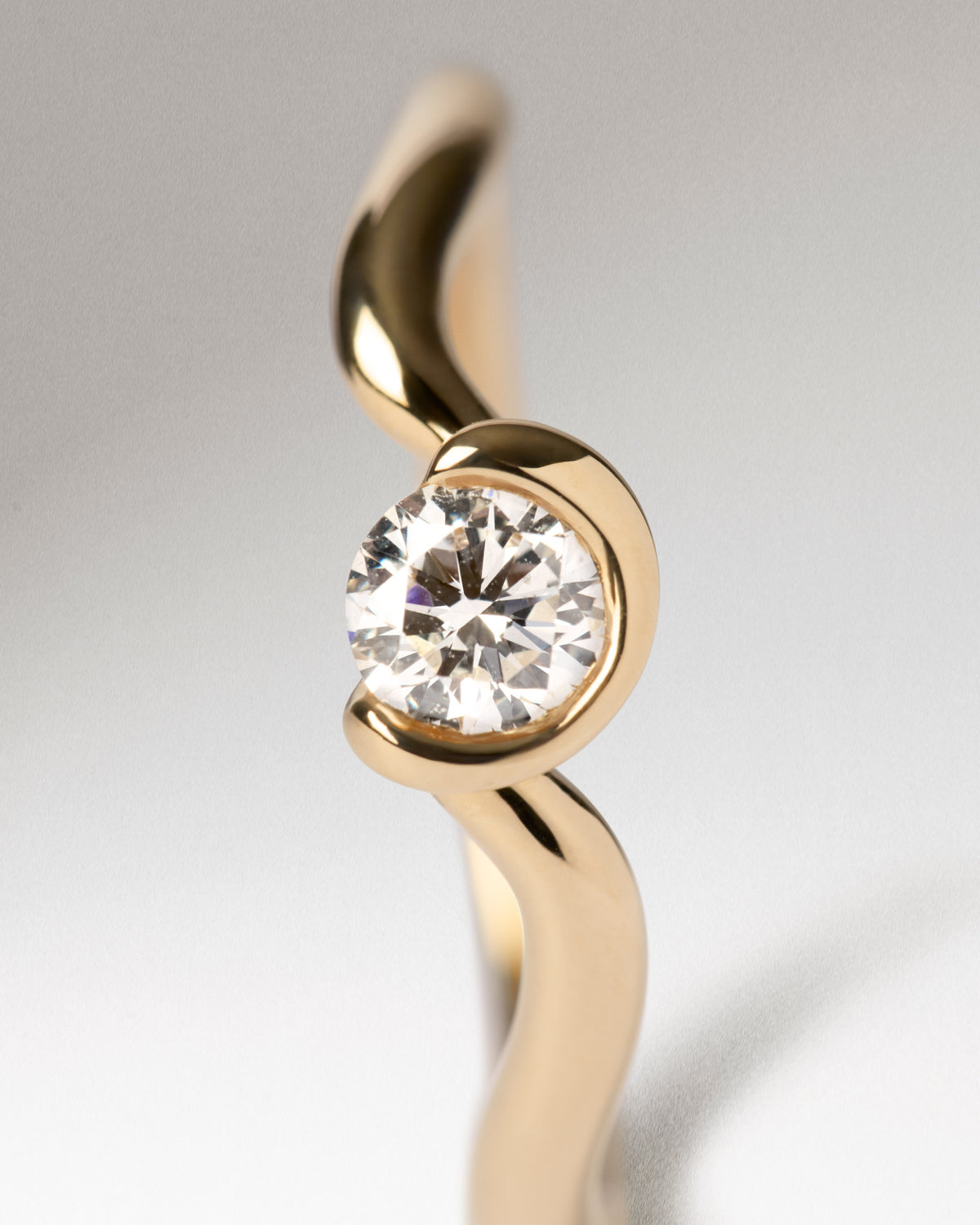 Anillo solitario elegante de oro de 18K con un diamante de laboratorio y líneas fludias