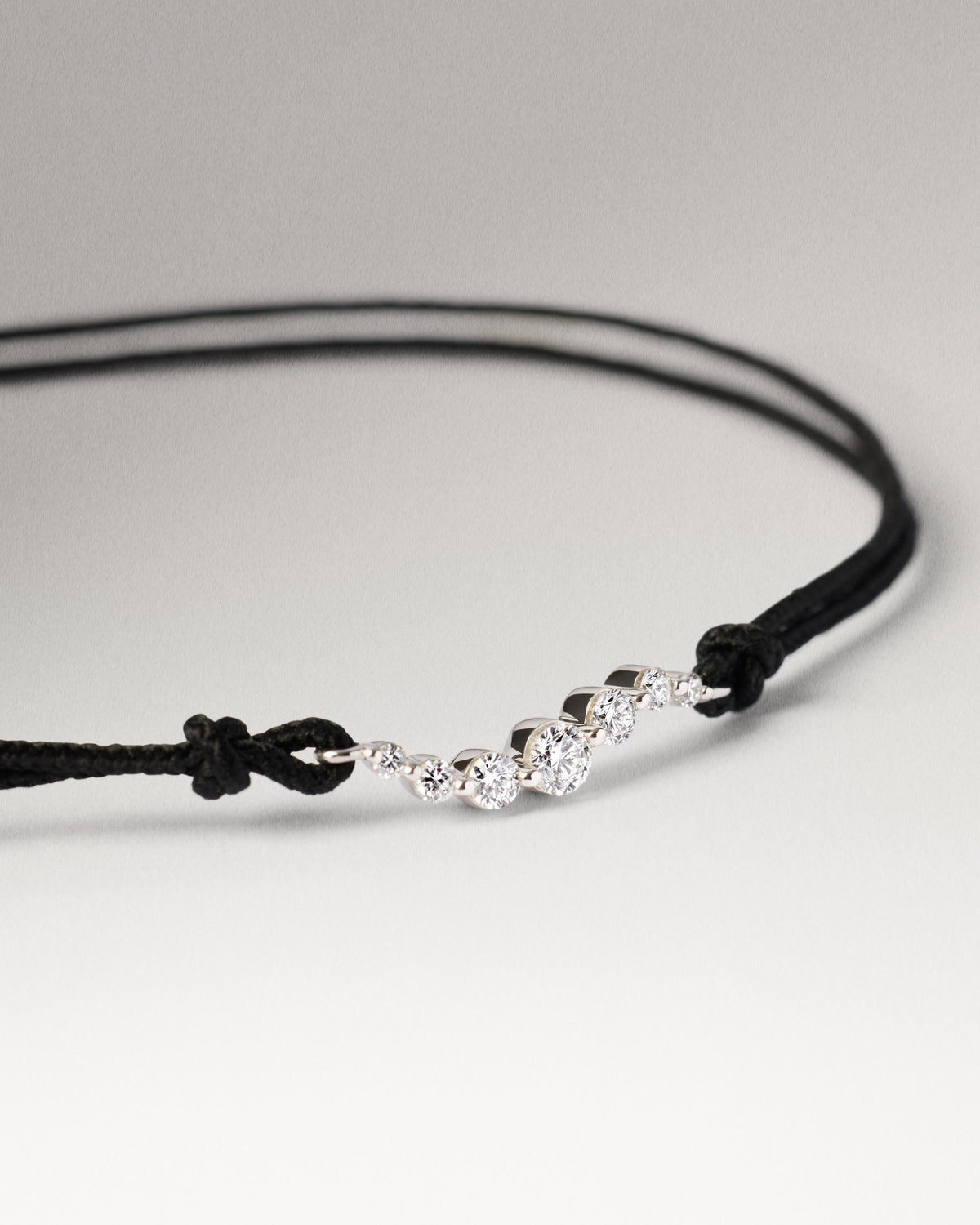 Adjustable diamond cord bracelet with a row of lab-grown diamonds in graduating sizes