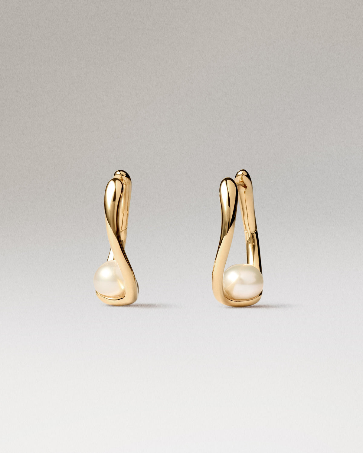 Aros de plata bañada en oro con un delicado detalle de perla.