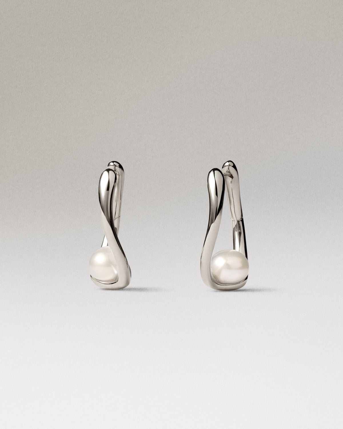 Silver hoop earrings with a delicate pearl detail