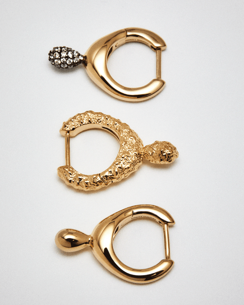 Aro individual de plata bañada en oro con forma fluida y un colgante pavé en forma de gota