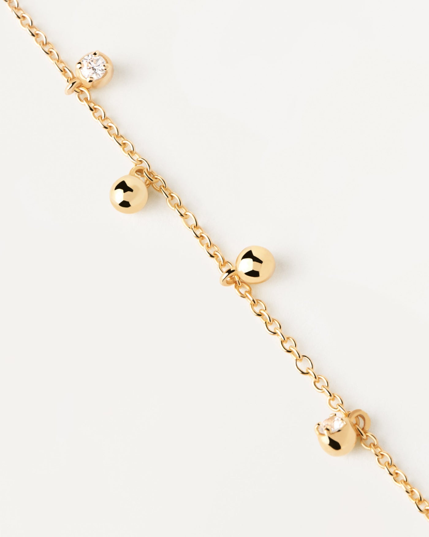 Gold-plated silver bracelet with small zirconia and ball pendants